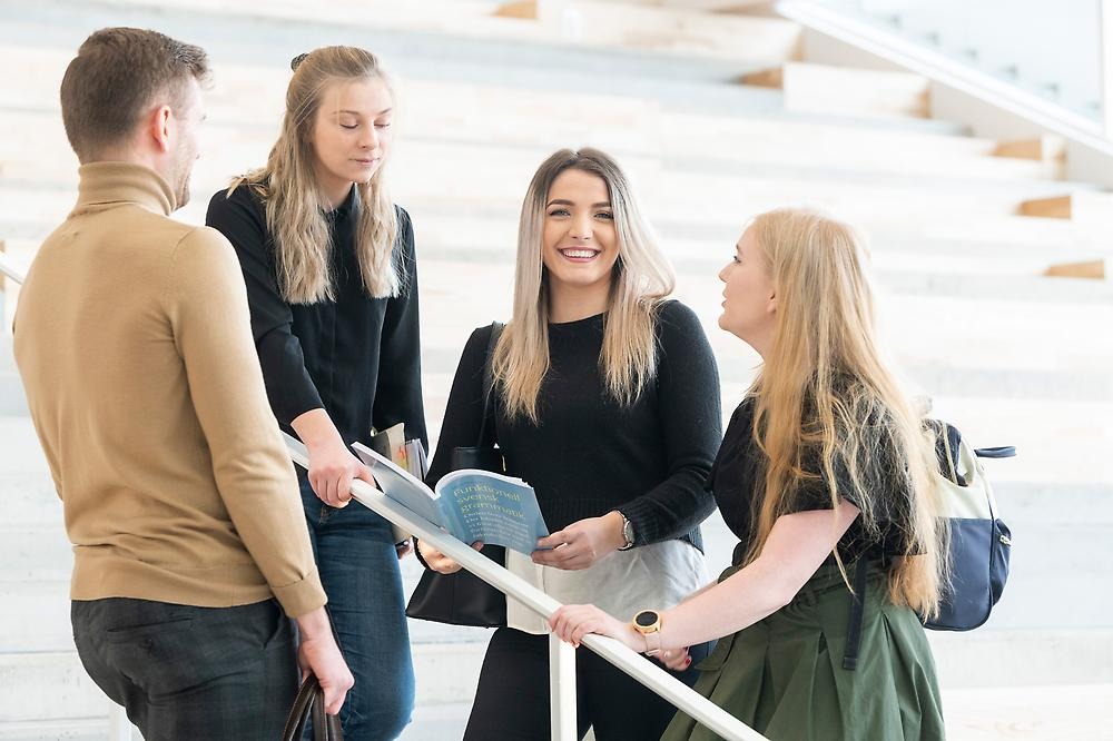 Fyra studenter samtalar i Eskilstuna campus.